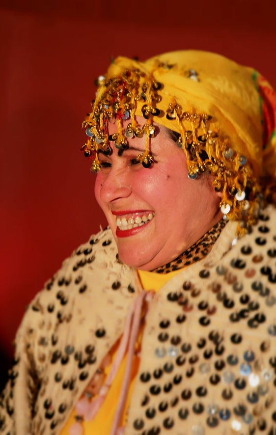 Smiling performer in Berber dress and coin jewellery at Chez Ali